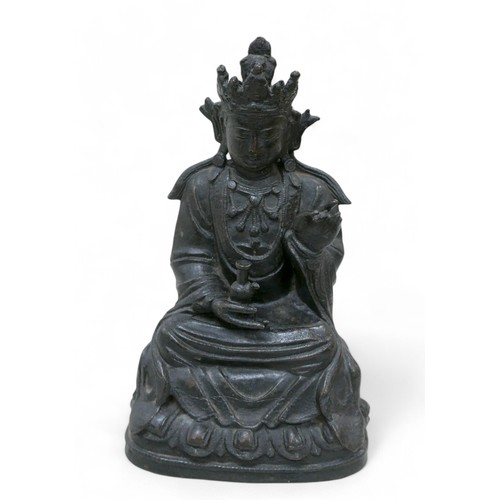 214 - A bronzed sculpture of Guanyin in a seated position, 21cm high.