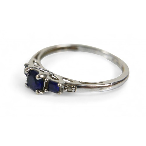 37 - A 9ct white gold and sapphire ring, the round cut central stone, 2.16mm diameter, is flanked by two ... 