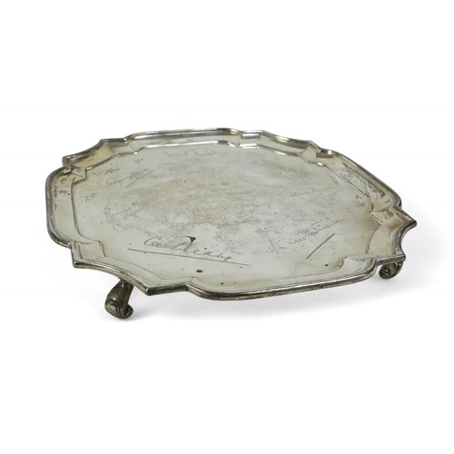 129 - A silver tray, London, four scroll feet and shaped pie crust edge, engraved with names, Goldsmiths a... 