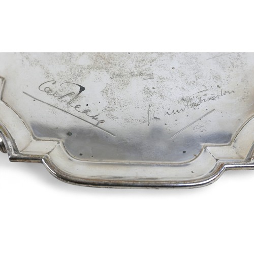 129 - A silver tray, London, four scroll feet and shaped pie crust edge, engraved with names, Goldsmiths a... 