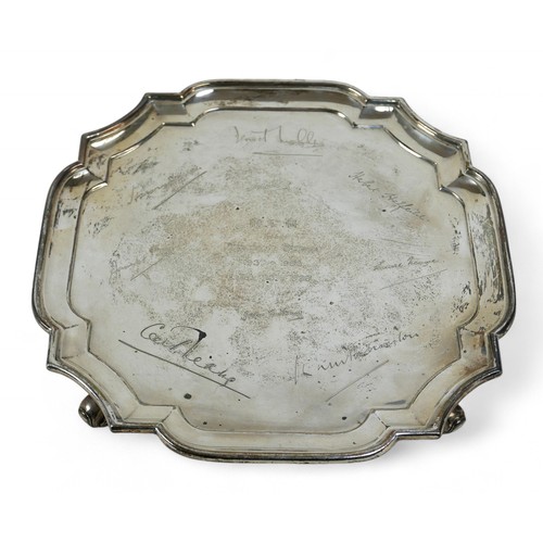 129 - A silver tray, London, four scroll feet and shaped pie crust edge, engraved with names, Goldsmiths a... 