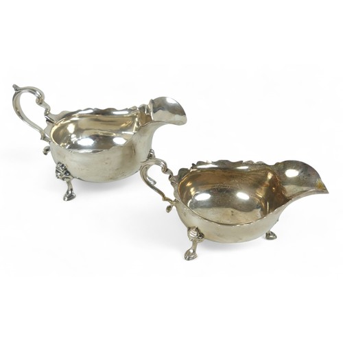 116 - Two silver sauce boats; one London 1937 by Asprey & Co, Birmingham, with shaped rim and three feet, ... 