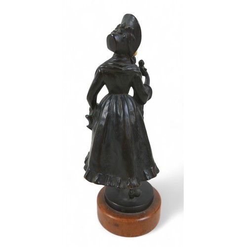 217 - An early 20th century bronze and ivory figure, modelled as a girl in a bonnet with flower basket, st... 