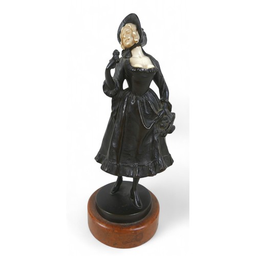 217 - An early 20th century bronze and ivory figure, modelled as a girl in a bonnet with flower basket, st... 