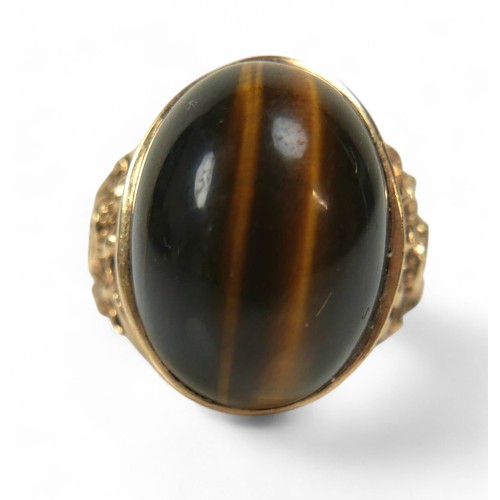 44 - A 9ct yellow gold tigers eye ring, size T, stone measures approximately 20 by 15 by 8mm, 9.7g.