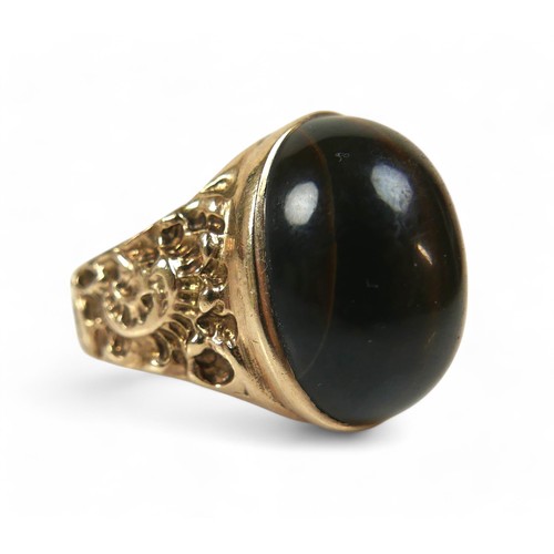 44 - A 9ct yellow gold tigers eye ring, size T, stone measures approximately 20 by 15 by 8mm, 9.7g.