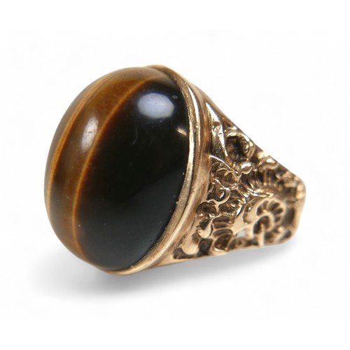 44 - A 9ct yellow gold tigers eye ring, size T, stone measures approximately 20 by 15 by 8mm, 9.7g.