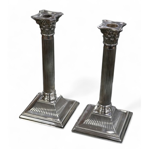 118 - A pair of silver Corinthian column candlesticks, Birmingham 1908, maker JS & S, square weighted base... 