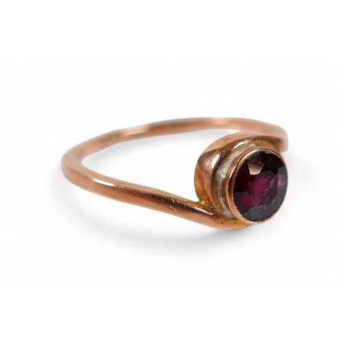 79 - A 9ct rose gold and garnet ring, the round cut garnet measure approximately 5.5mm diameter, in a rub... 