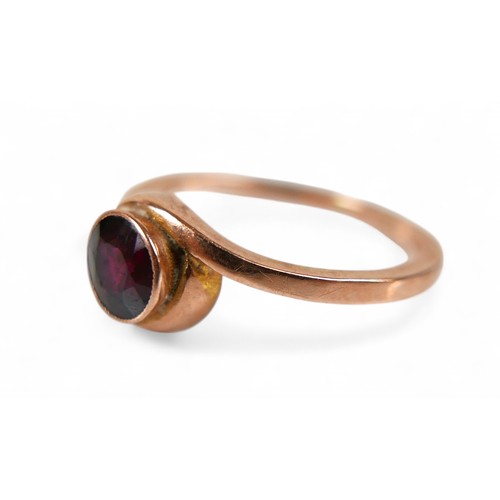 79 - A 9ct rose gold and garnet ring, the round cut garnet measure approximately 5.5mm diameter, in a rub... 