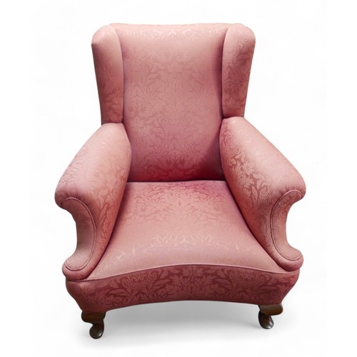 356 - An early 20th century wing back armchair, upholstered in pink 83cm by 94cm by 100cm high.