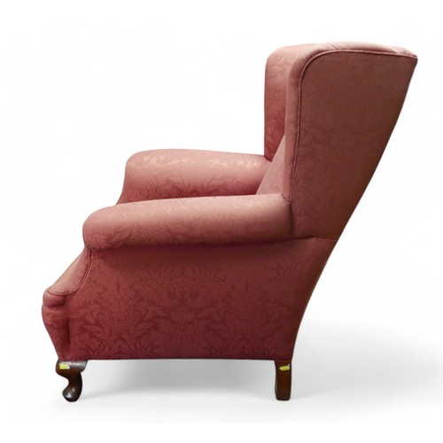 356 - An early 20th century wing back armchair, upholstered in pink 83cm by 94cm by 100cm high.