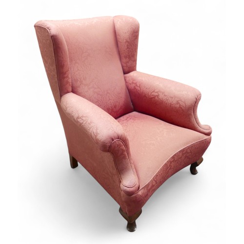 356 - An early 20th century wing back armchair, upholstered in pink 83cm by 94cm by 100cm high.