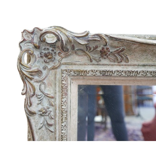 316 - A modern mirror in a swept frame, 107 by 5 by 77cm.