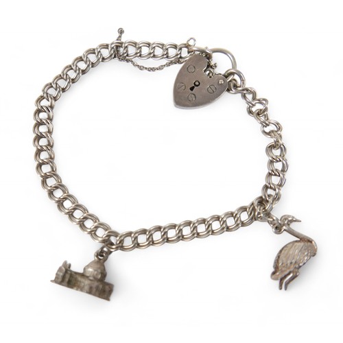 38 - A silver charm bracelet, with multiple charms, including an Eiffel Tower, Statue of Liberty, railway... 