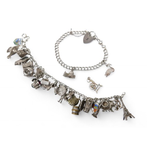 38 - A silver charm bracelet, with multiple charms, including an Eiffel Tower, Statue of Liberty, railway... 