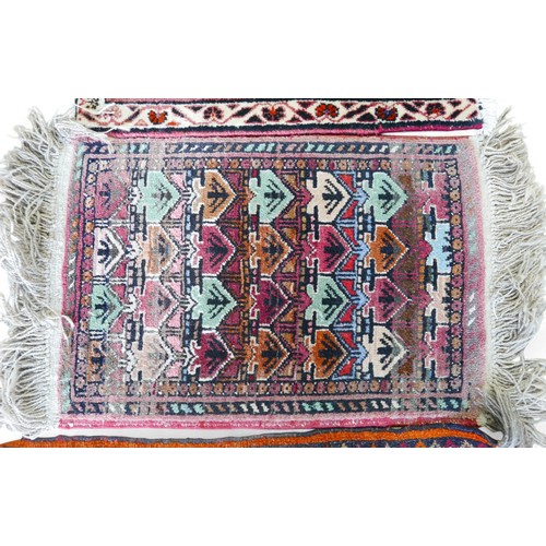 336 - A collection of four small hand knotted rugs, largest 52 by 80cm. (4)