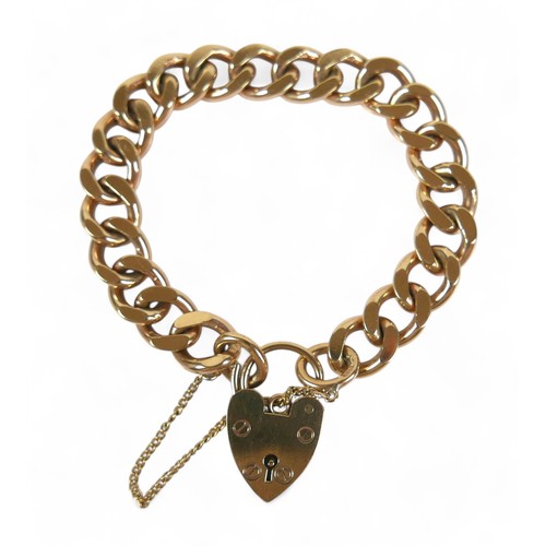 90 - A 9ct yellow gold kerb link bracelet, with heart shaped padlock clasp and attached safety chain, 10.... 