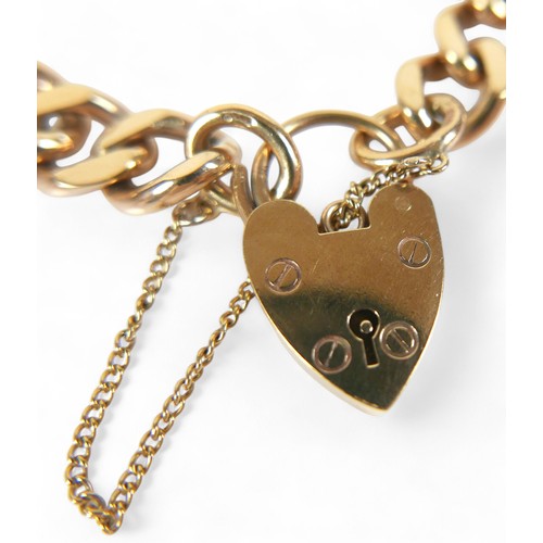 90 - A 9ct yellow gold kerb link bracelet, with heart shaped padlock clasp and attached safety chain, 10.... 