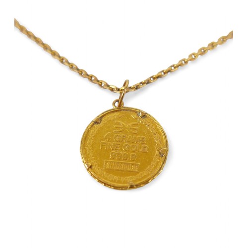 76A - A gold chain with assorted gold charms and rings, including a 999.9 gold medallion and small mutton ... 