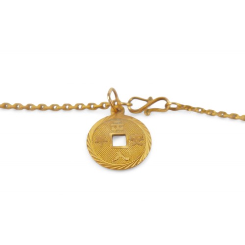 76A - A gold chain with assorted gold charms and rings, including a 999.9 gold medallion and small mutton ... 