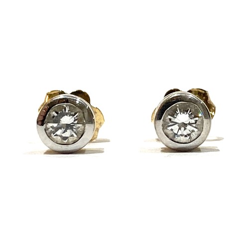 58A - A pair of 18ct white and yellow gold diamond stud earrings, each round brilliant cut stone, approxim... 