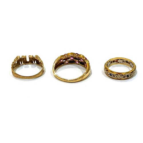 65A - A group of three gold rings, comprising an 18ct white and yellow gold ring set with small dark blue ... 