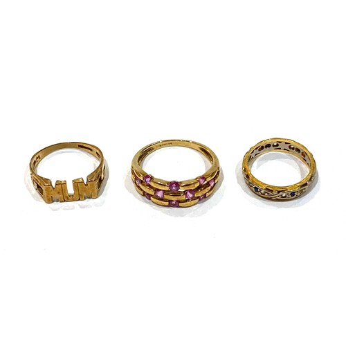 65A - A group of three gold rings, comprising an 18ct white and yellow gold ring set with small dark blue ... 