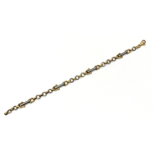 73A - A yellow gold and platinum equestrian theme bracelet, with links in the shape of stirrups, spurs, an... 