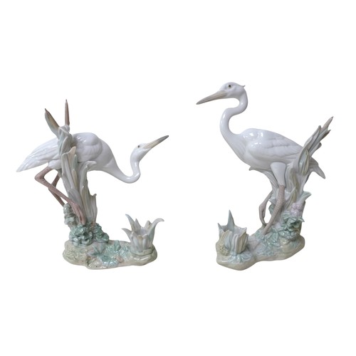 182 - A pair of Lladro heron candlesticks, a Copenhagen B&G figure and two further Lladro figures. (5)