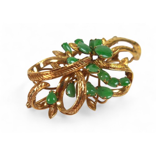 93 - A 10k gold and jade spray brooch, the ribbon and leaf design set with fifteen cabochon jades in oval... 