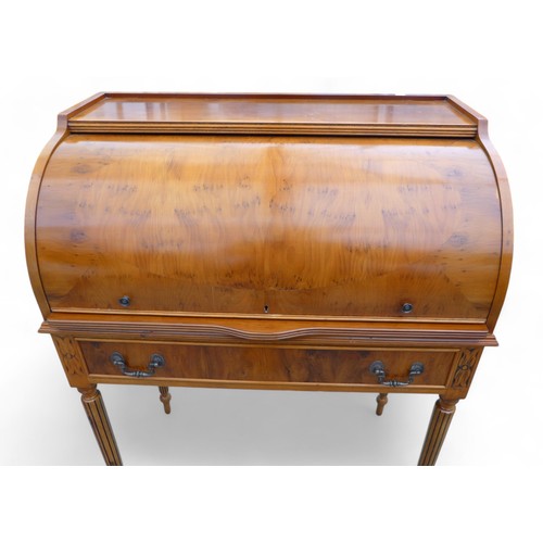 244 - A 20th century yew wood cylinder top writing desk, with a fitted interior above a drawer on turned r... 