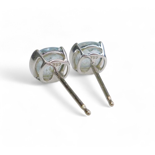 45 - A pair of 18ct white gold aquamarine stud earrings, head size 7 by 6mm, weight 1g.