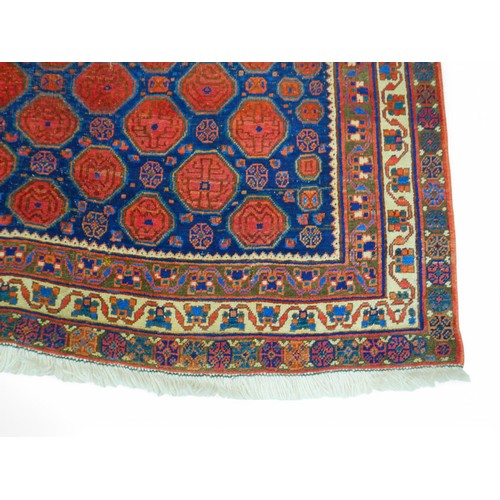 190 - A hand knotted woolen persian rug, with a blue field and stylised border, 129 by 190cm.