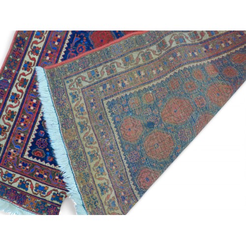 190 - A hand knotted woolen persian rug, with a blue field and stylised border, 129 by 190cm.