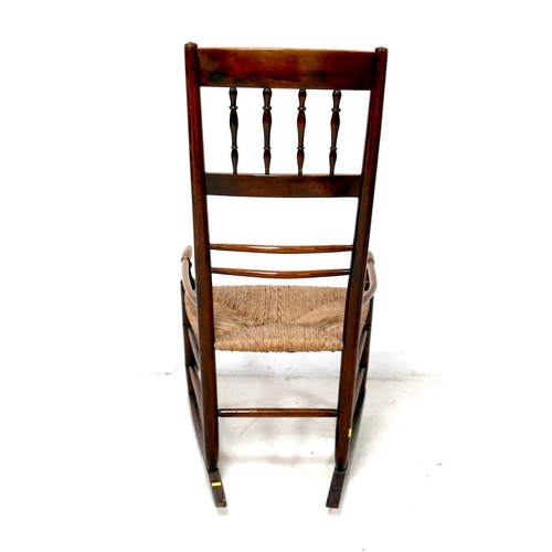 193 - A 19th century oak country spindle back open armchair, later converted to a rocking chair, with rush... 