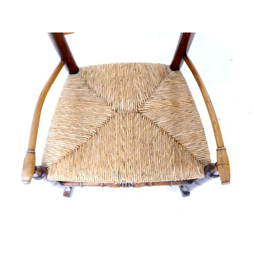 193 - A 19th century oak country spindle back open armchair, later converted to a rocking chair, with rush... 