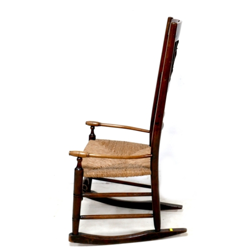 193 - A 19th century oak country spindle back open armchair, later converted to a rocking chair, with rush... 