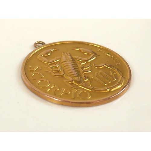 54 - A 9ct yellow gold pendant, of circular form cast in relief with the zodiac sign of Scorpio, by P. Vi... 