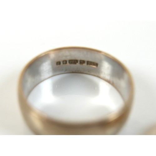 62 - A group of three rings, comprising an 18ct yellow gold wedding band ring, 4.5mm wide, size N, 3.8g, ... 