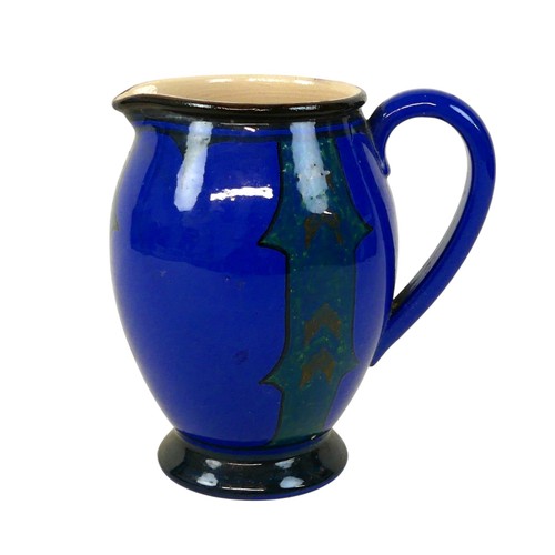 106 - An Arts & Crafts Devon Pottery jug, decorated in a blue and green glaze, 19cm high.