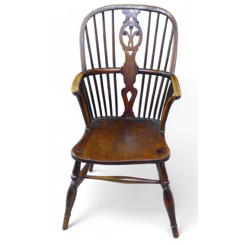 324 - A 19th century ash and elm stick back Windsor elbow chair, with a fleur de lys splat, 47 by 56 by 96... 