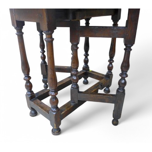 295 - A 19th century oak gate leg table with an oval drop leaf top on turned supports, 77 by 85cm by 69cm ... 