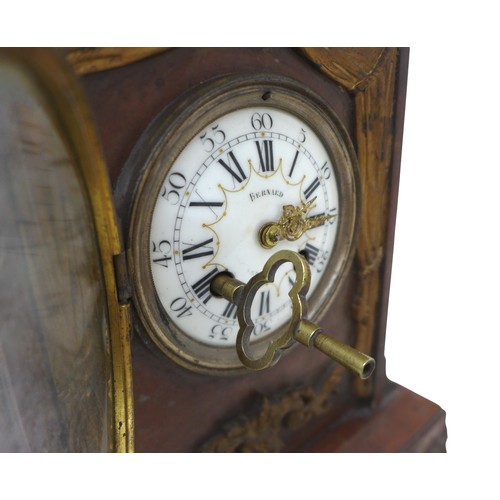 216 - A French 19th century mantel clock, the red marble case decorated with floral swags and surmounted b... 