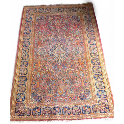 332 - A pair of hand knotted woolen Kashan Persian rugs, with a central medallion on a red field and styli... 