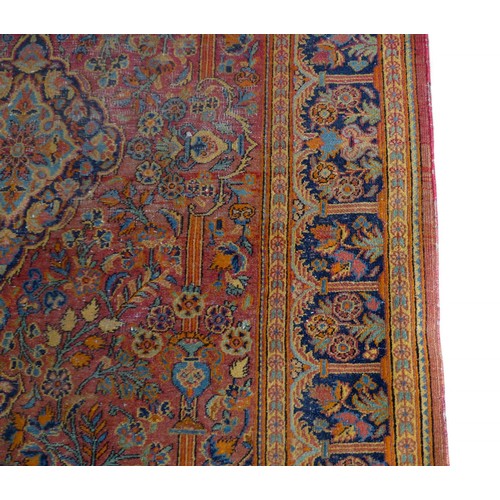 332 - A pair of hand knotted woolen Kashan Persian rugs, with a central medallion on a red field and styli... 