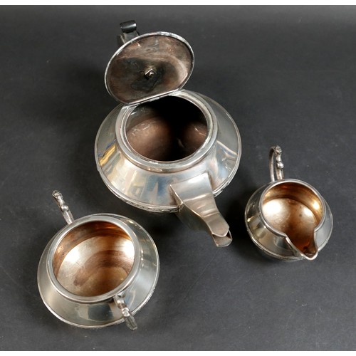 29 - A George V silver three piece tea service, of compressed ovoid form on a circular foot, with a decor... 