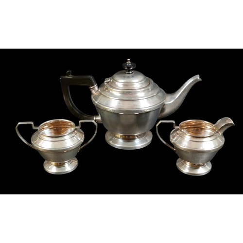 33 - A George VI silver three piece tea service, of stepped form on a circular foot, comprising teapot, 2... 