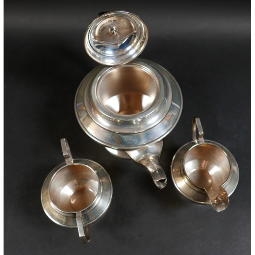 33 - A George VI silver three piece tea service, of stepped form on a circular foot, comprising teapot, 2... 