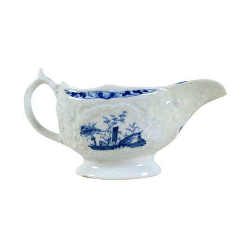 137 - An 18th century Lowestoft porcelain small sauce boat, decorated with moulded exterior and in undergl... 